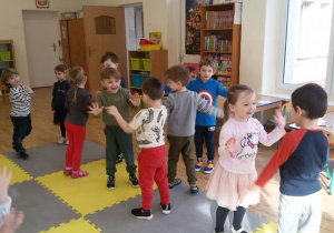 Widok na grupę tańczących w parach dzieci.